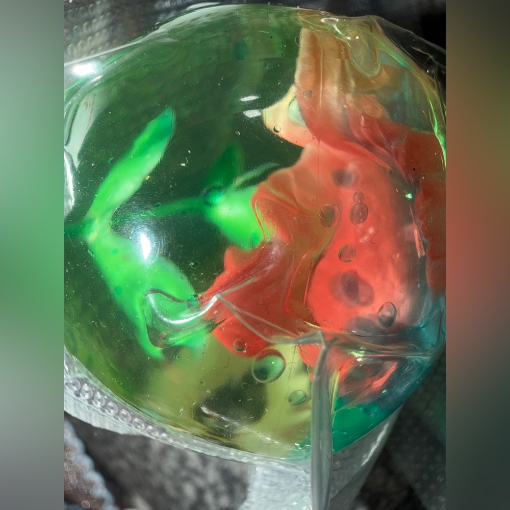 stress ball" or "squishy" toy containing a small fish figurine inside.